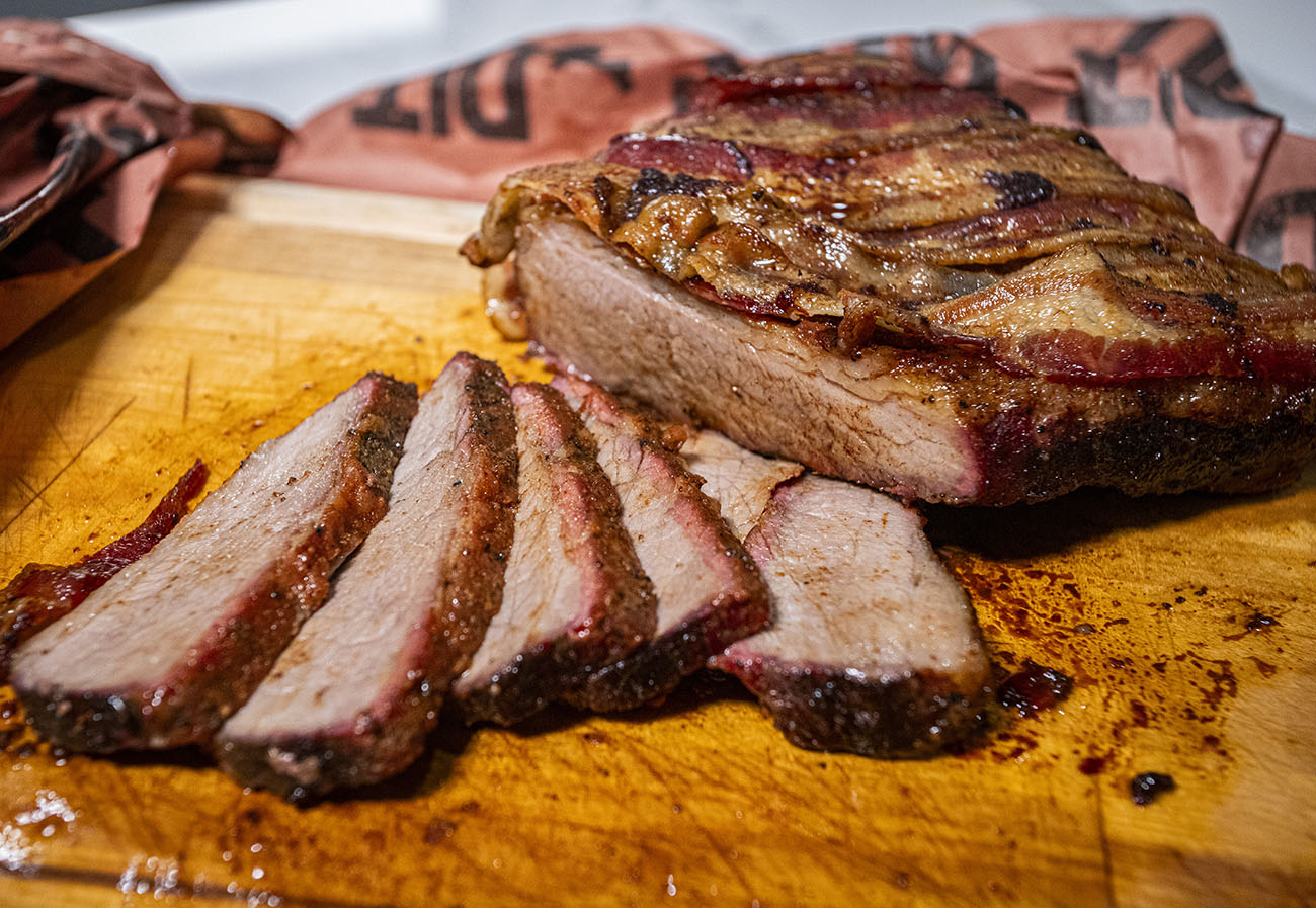 Smoked Brisket wrapped in bacon, sliced on cutting board with pit boss butcher paper