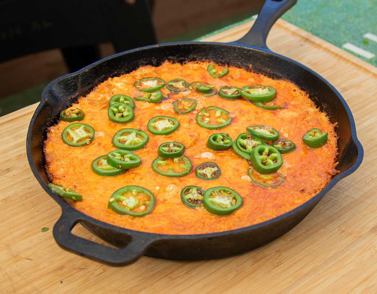 cheesy buffalo chicken dip served with jalapenos and tortilla chips