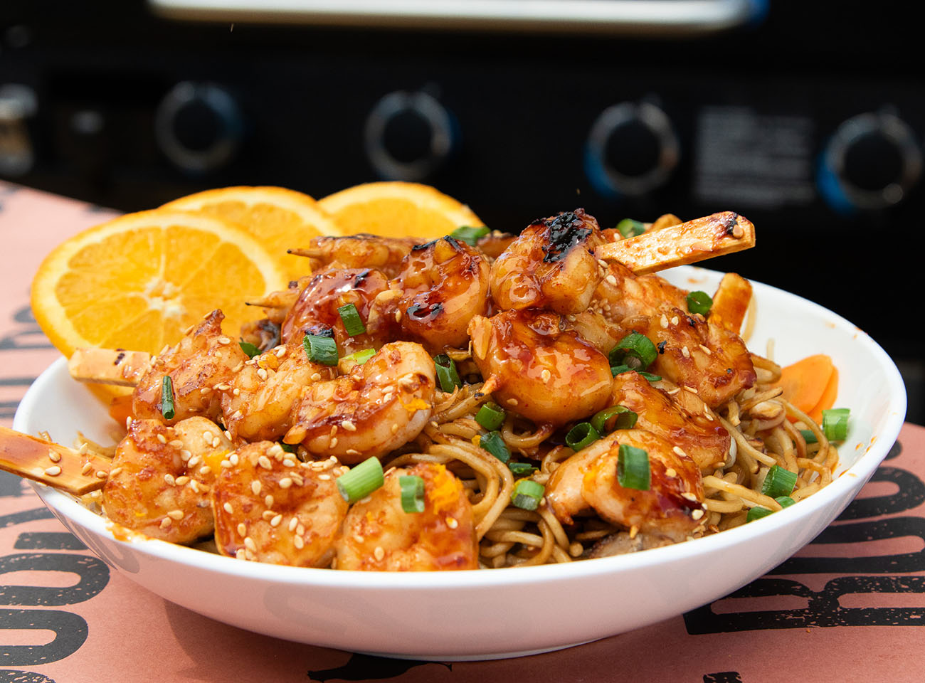 Spicy orange citrus shrimp over a garlic Yakisoba stir fry noodle with sesame seeds and scallions