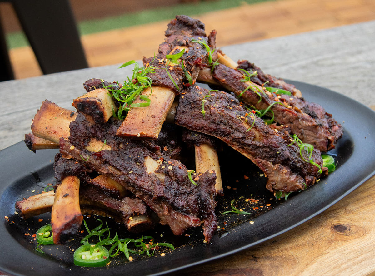 grilled and braised beef back ribs seasoned with Pit Boss Cowboy butter, cooked on Pit Boss wood pellet grill. Plated on black plate with pepper garnish